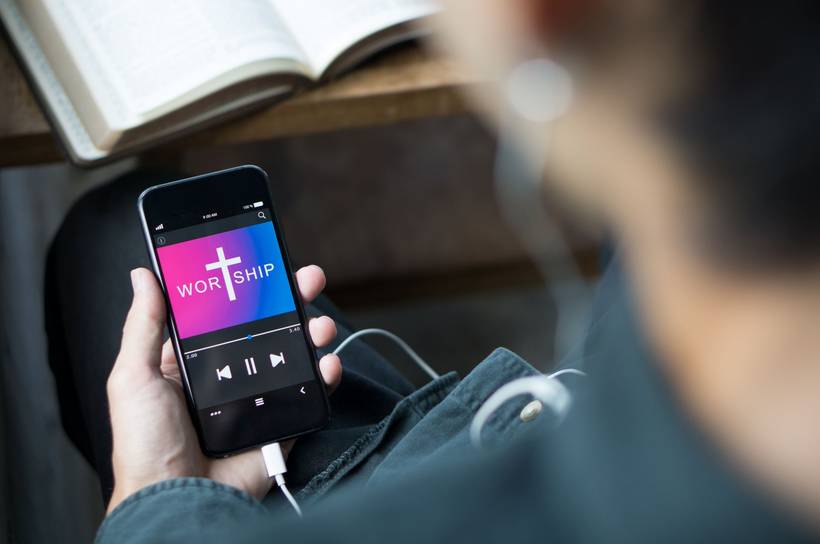 Devotional app on a phone beside an open Bible